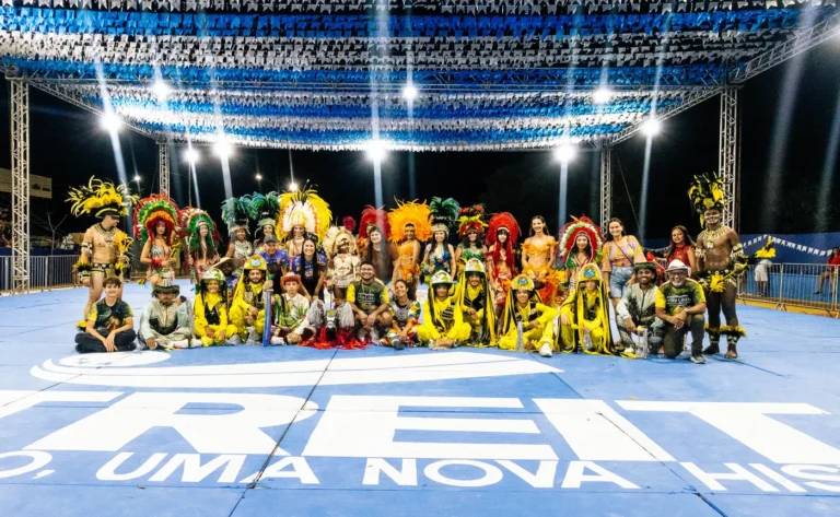 Brincantes do Boi do Favela posam na arena iluminada ao fim de uma apresentação de festa junina