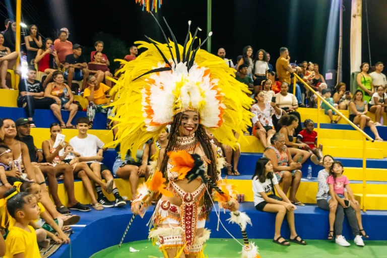 Dançarina do Boi do Favela se apresenta diante da arquibancada cheia de crianças e famílias