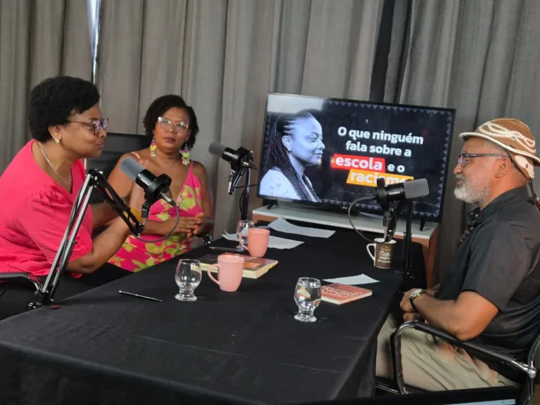 Convidadas participam do debate sobre escola e racismo diante de microfones e do telão