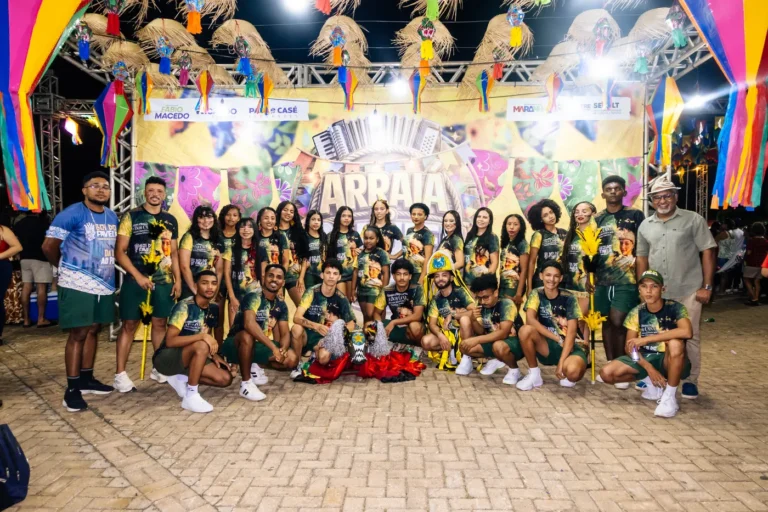 Integrantes do Boi do Favela com as camisetas do projeto posam no palco do arraial