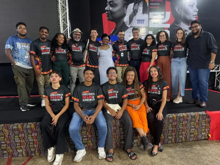 Equipe organizadora do Movimento Consciência Negra e Democracia reunida com as camisetas do movimento