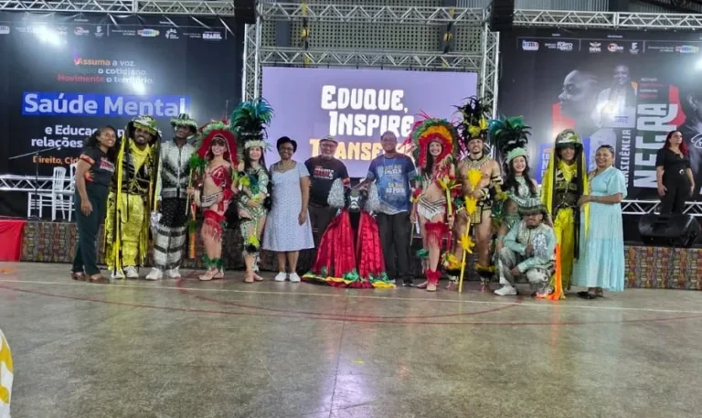 Grupos culturais com figurinos coloridos posam no palco do encerramento