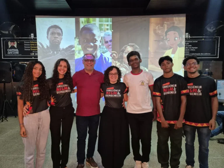 Grupo posa diante da tela de projeção depois da sessão de cinema do movimento
