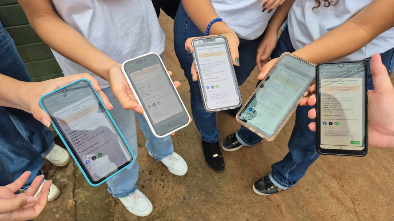 Jovens mostram os celulares com o voto confirmado para a CIATDAL no Prêmio Periferia Viva