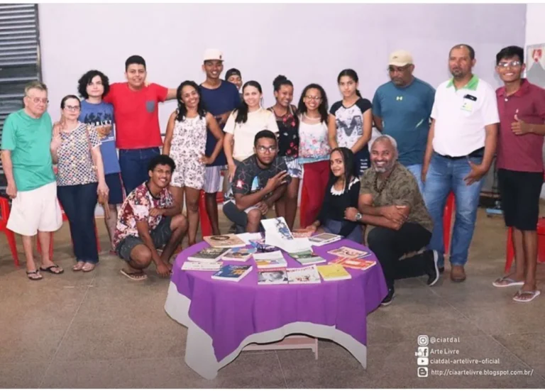 Participantes do Projeto Leia Mais reunidos em volta de uma mesa com livros espalhados