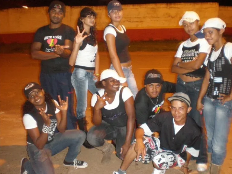 Jovens do Grupo Arte Livre reunidos na rua à noite, alguns com a camiseta do grupo, em Porto Franco